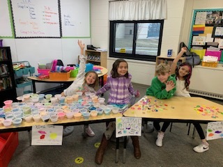 Students stand in front of a table full of slime.